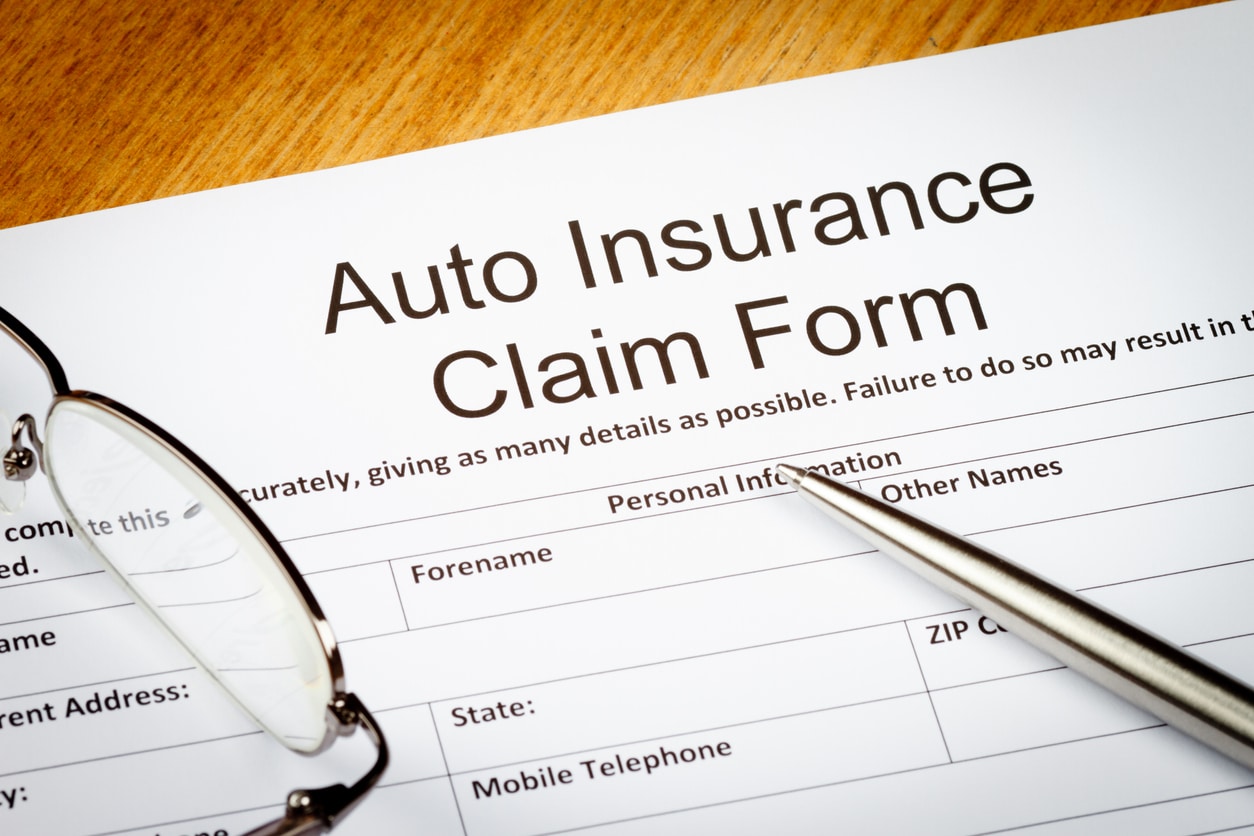 Filing for third-party claim concept, an auto insurance claim form about to be filled out.