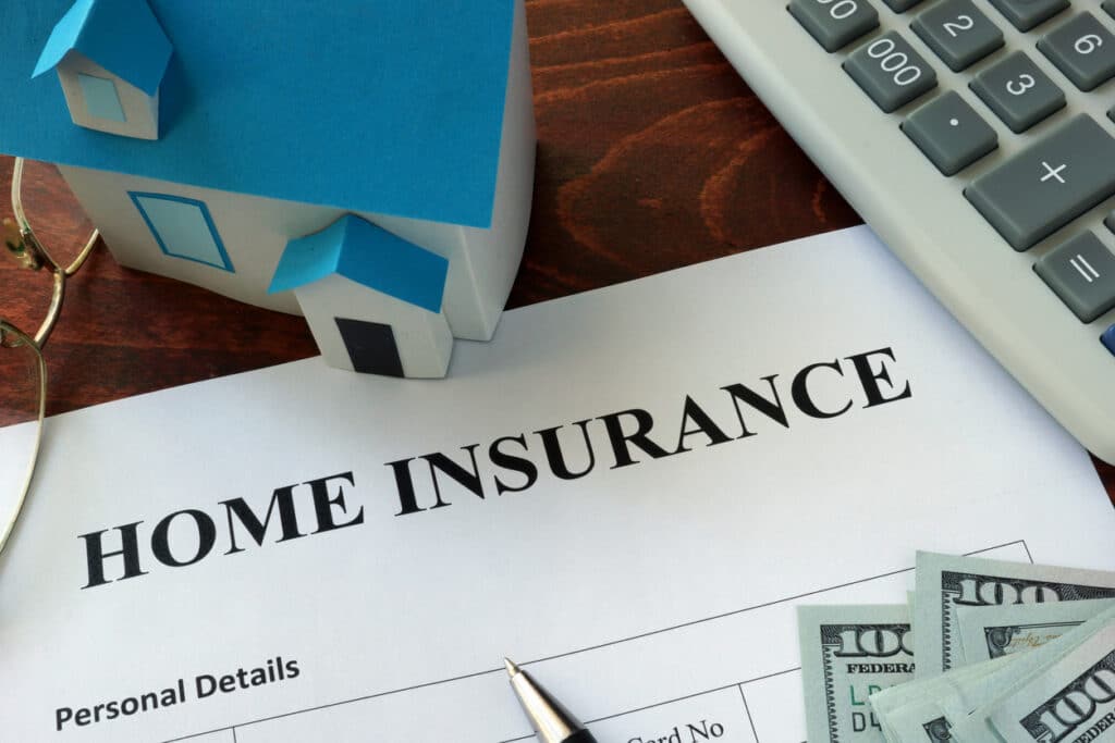Home insurance form on a table with dollar bills and a calculator - a concept of home insurance rate.