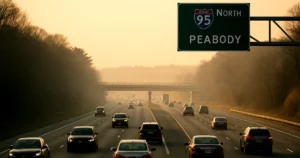 Massachusetts auto insurance rates illustrated through vehicles driving on a state highway against a subtle economic backdrop.